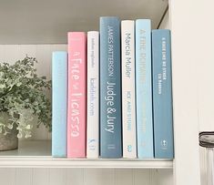 some books are sitting on a shelf next to a potted plant