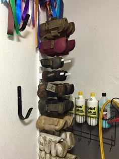 there are many pairs of shoes hanging on the wall next to each other and some cleaning products