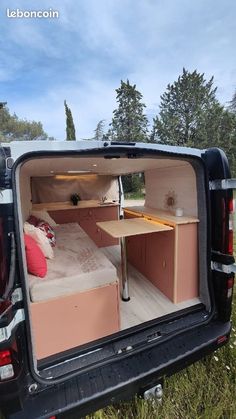 the back end of a van with a bed and desk in it's trunk