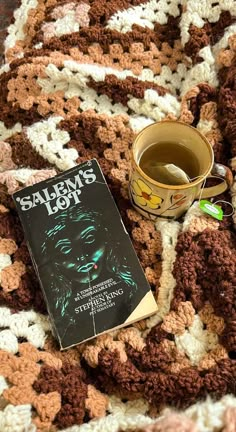 a coffee cup and book on a crocheted blanket with the title salem's lights