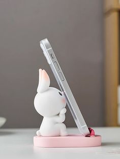 a little white bunny holding a cell phone