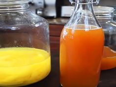 orange juice in a glass bottle next to some jars