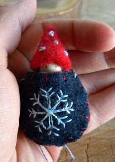 a hand holding a small needle felt ornament