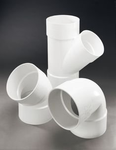 three white cups stacked on top of each other in the middle of a black background