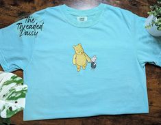 Comfort Colors Embroidered Classic Pooh and Piglet Holding Hands   Welcome to The Threaded Daisy store. Thank you for visiting!  Production & Shipping: Everything is embroidered to order just for you. On average your items will be shipped out within 2-4 days of ordering. The estimated shipping time in the US is 5-7 business days. Washing Instructions: Wash inside out, in cold water, on a gentle cycle.  Tumble dry on low or let air dry. Feedback: If you have any issues with your order please contact us directly! We would love to resolve the issue and ensure you are happy with your new embroidered apparel!  We appreciate your business! Wardrobe Planning, Embroidered Clothes, Embroidered Shirt, Winnie The Pooh, Comfort Colors, Gender Neutral, Tops & Tees, Adult Outfits, Top Outfits