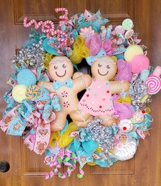 a wreath with two gingerbread men and candy canes on the front door for christmas