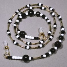 This eyeglasses chain is made with graduated sizes of round black glass beads, black and white glass seed beads and shiny gold colored bugle beads. The neutral colors will go with anything and will be a great gift for either a man or woman. Length - 28" (71.12 cm) Weight - 1.27 oz. (36 grams) Multi-strand stringing wire Silicone ends Black Glass Beaded Necklaces With Colorful Beads, Black Glass Beaded Necklace With Colorful Beads, Black Glass Beaded Necklaces With Beaded Chain, Black Glass Beaded Necklace With Beaded Chain, Black Glass Round Bead Jewelry, Black Glass Round Beads Jewelry, Black Glass Beaded Jewelry, Adjustable Glass Beaded Necklace With Black Beads, Adjustable Black Beaded Glass Necklaces