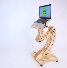 a laptop computer sitting on top of a wooden stand