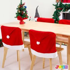 a wooden table topped with red chairs covered in santa claus's hats and christmas trees