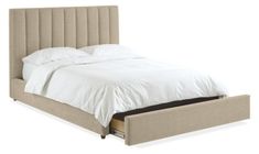 a bed with a white comforter and pillows on it's headboard is shown