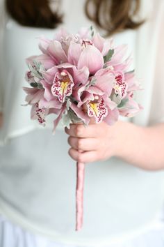 a woman holding a bouquet of pink flowers