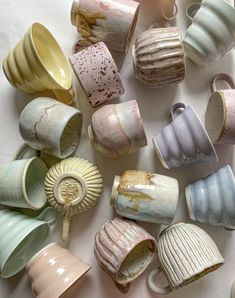 there are many different cups that have been made to look like seashells on the table