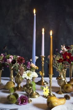 a table topped with lots of different types of flowers and candles