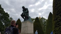 there is a statue in the middle of a park with people standing around and taking pictures