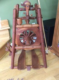 a wooden spinning machine sitting on top of a hard wood floor