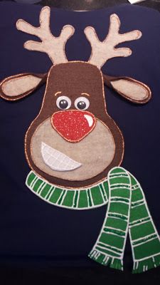 a pillow with a reindeer on it and a green scarf around its neck is shown