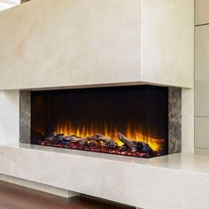 an electric fireplace in a living room with wood flooring and white walls, is shown