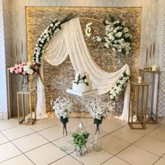 a wedding cake and flowers on display in front of a wall