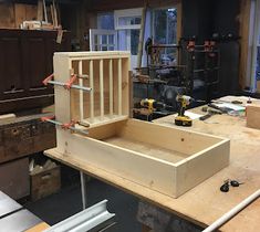 a workbench with tools and wooden boxes on the table in front of it