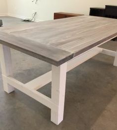 a wooden table with white legs in a room