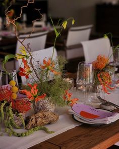 the table is set with flowers and wine glasses