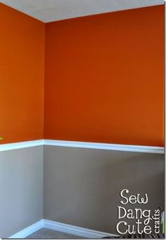 an empty room with orange walls and white trim