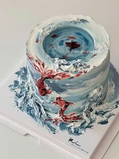 a cake with red and blue frosting on top is sitting on a white box