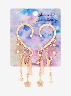 Keep your aesthetic celestial with these gold-tone ear cuffs! They have drop charms of pink faux crystals and hearts  plus gold-tone celestial icons and cherry blossom pendants. Celestial Icons, Aesthetic Celestial, Heart Ear Cuff, Asian Accessories, Stacked Earrings, Anime Accessories, Magical Jewelry, Exclusive Jewelry, Ear Cuffs