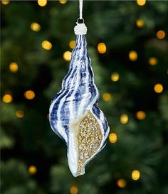 a blue and white ornament hanging from a christmas tree