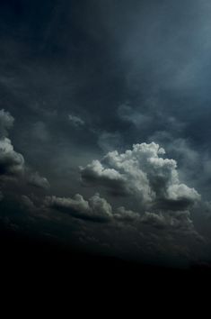 an airplane is flying in the sky with dark clouds behind it and sun shining through