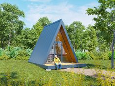 a man sitting on the ground in front of a triangular shaped building