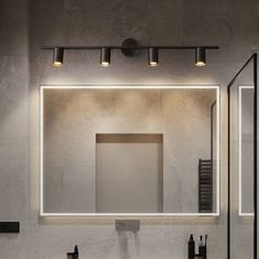 a bathroom with a sink, mirror and lights on the wall in front of it