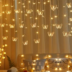 a living room filled with lots of lights and furniture covered in butterflies hanging from the ceiling