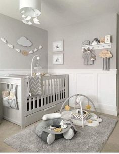 a baby's room with grey walls and white furniture