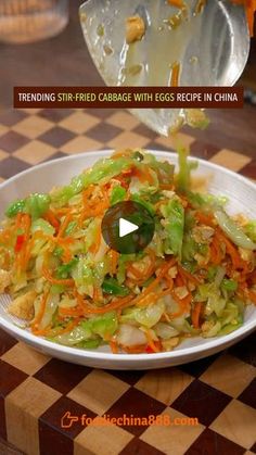 a white plate topped with shredded cabbage next to carrots and celery on top of a checkered table