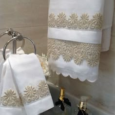 towels and wine bottles are sitting on the counter in front of a sink with gold trimmings