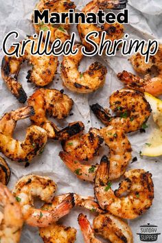 grilled shrimp on parchment paper with lemon wedges