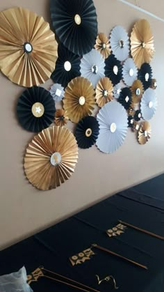 some black and gold paper fans are hanging on the wall