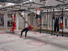 several people doing aerial tricks in a gym