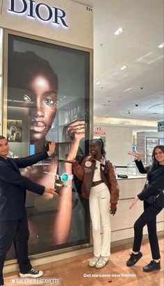 three people taking pictures in front of a store window