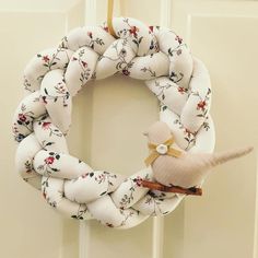 a wreath hanging on the front door with a bird and flower print fabric wrapped around it