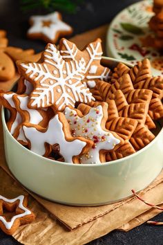 a white bowl filled with cut out gingerbread cookies on top of a wooden table