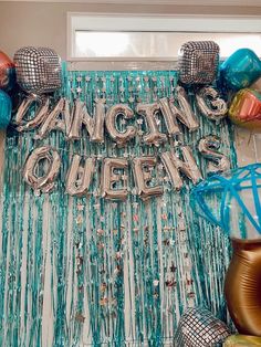 there is a sign that says dancing queens on it and some balloons in the background