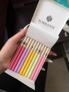 a person holding a box of colored pencils