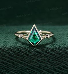 a green ring with two diamonds on top and one diamond in the middle, sitting on a green cloth