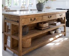 a large kitchen island with two sinks and an open shelf on the side in front of it