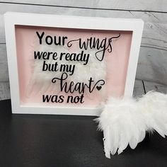 a white feather sitting in front of a pink frame with the words, your wings were ready but my heart was not