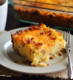 a slice of breakfast casserole on a plate with a fork next to it