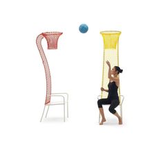 a woman sitting on a chair in front of a basketball net and an object that looks like a pole