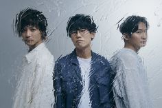 three young men standing next to each other in front of a mirror with water droplets on it